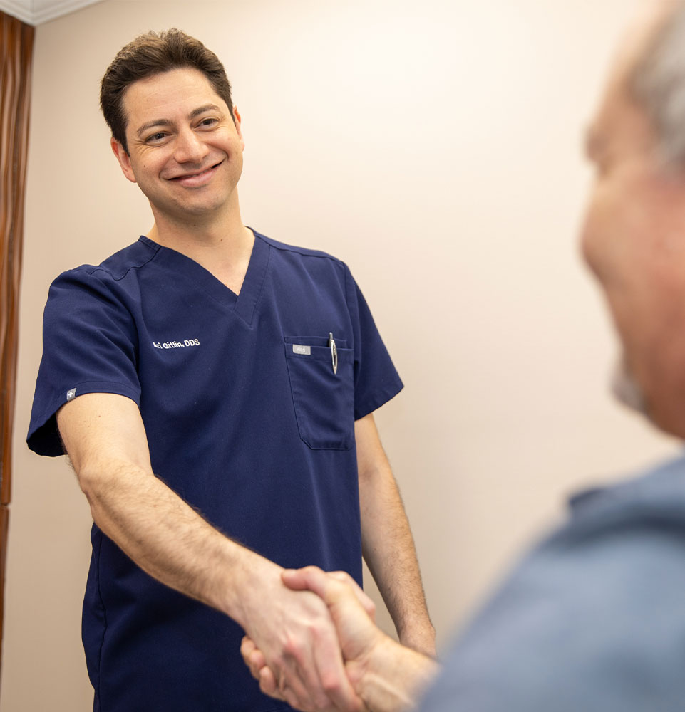 doctor shaking hands with patient within the dental center